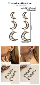 Macro detail of triple crescent moon drop earrings with rhinestones in gold and silver