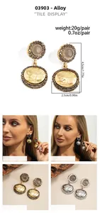Detail view of retro alloy earrings with grey beads, rhinestones and hammered metal plates