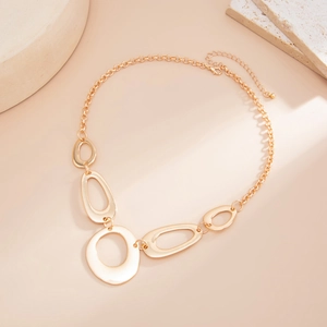 Detail of minimalist golden waist chain with abstract oval metal ring links on a stone base