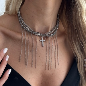Nahaufnahme eines Lagen-Chokers mit grauen Perlen und funkelndem Strass-Kreuzanhänger