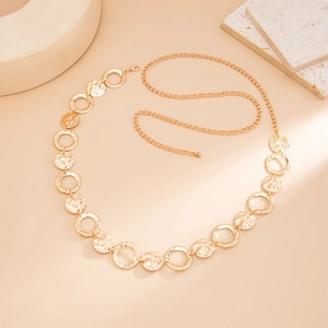 Detail of gold metal body chain with hollow rings and hammered texture discs