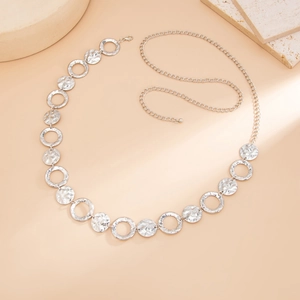 Macro detail of silver geometric waist chain featuring hammered textured metal circles