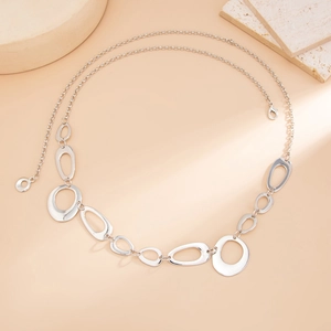 Detail of silver hollow ring body chain with lobster clasp on orange background