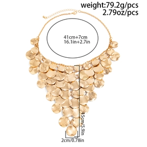 Detailed view of layered gold circular metal discs on a statement bib necklace
