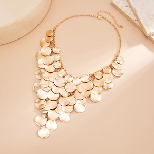 Detail of layered gold metal discs necklace with textured finish and lobster clasp