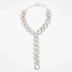 Macro shot of silver Y-shaped necklace featuring textured round discs and long chain links