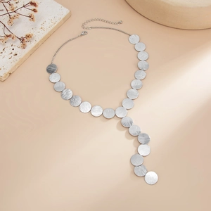 Detail of silver geometric disc necklace with brushed metal texture and lobster clasp