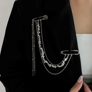 Detail of silver tassel chain brooch with stars on black suit jacket lapel