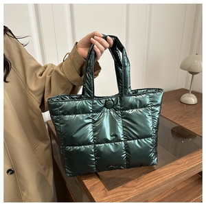 Détail du sac cabas matelassé vert foncé avec coutures à carreaux et bouton pression métal