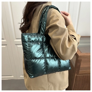 Sac fourre-tout matelassé vert métallisé porté à l'épaule dans un décor lifestyle