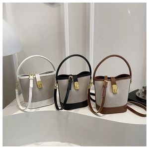 Three stylish bucket bags in black, white, and brown with canvas and leather patchwork