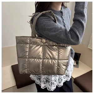 Détail d'un sac cabas matelassé or champagne avec finition métallisée et bouton-pression