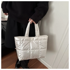 Détail du sac cabas matelassé argenté en duvet avec fini métallisé et fermeture à bouton