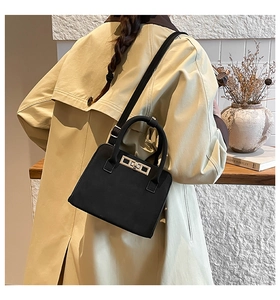 Detailed back view of a black frosted suede small handbag with a gold metal turn-lock closure