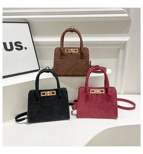 Three suede handbags in brown, black and burgundy with gold twist locks and top handles