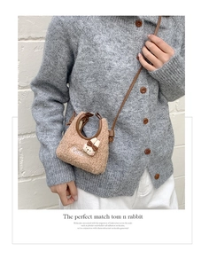 Detail einer braunen Teddy-Fleece Mini-Umhängetasche mit Hasen-Anhänger und Stickerei