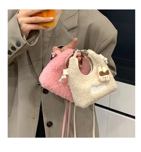 Detail der Mini-Tasche aus Lammwolle mit Cutie-Stickerei und süßer Hasen-Deko