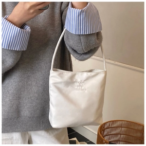 Détail du sac seau blanc en nylon avec broderie Hope and Future sur la face avant