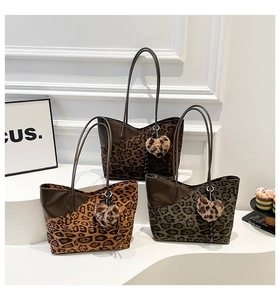 Detailed view of leopard print tote bags in brown, yellow, and green with plush heart charms