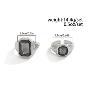 Dettaglio di anelli in argento con gemme acriliche grigie taglio smeraldo e cushion