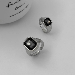 Dettaglio di due anelli regolabili in argento con pietre di zircone nero a taglio quadrato