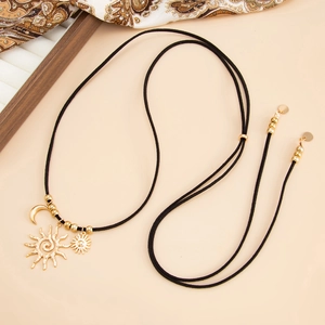 Primo piano di una collana boho con pendenti sole e luna e cordoncino nero regolabile