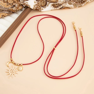 Dettaglio collana lunga in pelle scamosciata rossa con ciondoli sole e luna