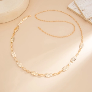 Detail of golden waist chain showing hammered texture oval links and lobster clasp