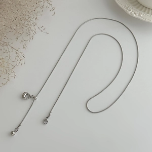 Detail van zilveren slangenketting met verstelbare schuifkraal en hartvormige hanger