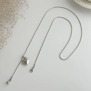 Detail van de zilveren slangenketting met hartvormige hanger en verstelbaar Y-ontwerp