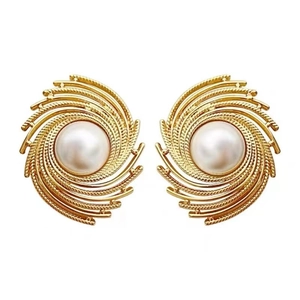 Elegant gold spiral pearl stud earrings featuring textured brass with a lustrous white pearl
