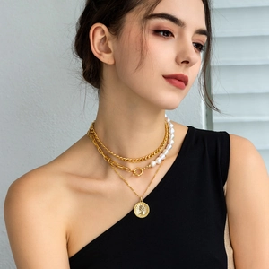 Three-layer layered necklace featuring baroque pearls and a vintage coin pendant detail