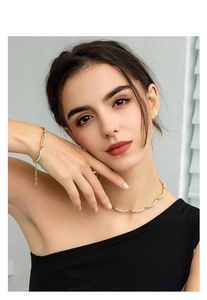 Detail of 18K gold-plated bamboo-style pearl necklace and bracelet set on model
