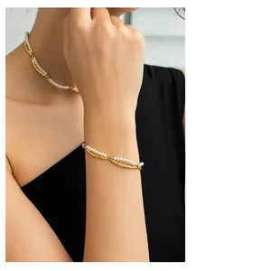 Detailed view of layered pearl bamboo joint necklace and bracelet set in gold plating