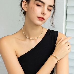 Detail of 18K gold-plated double-layer pearl necklace and bracelet on model skin