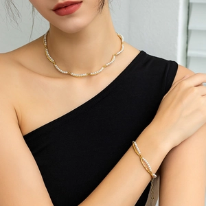 Detail of 18K gold-plated bamboo-style layered pearl necklace and bracelet set