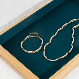 Close-up of pearl necklace and bracelet set in vintage bamboo design with 18K gold finish