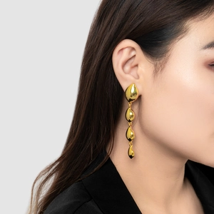 Minimalist 18K gold plated teardrop tassel earrings worn by model for elegant style