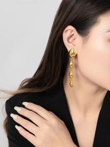 Detail of 18K gold teardrop tassel earrings showing polished finish and elegant drape