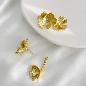 Orecchini vintage a fiore placcati oro 18K con texture 3D su sfondo di seta bianca