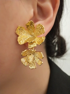 Orecchini a doppia fiera placcati oro 18K con texture martellata indossati da modella
