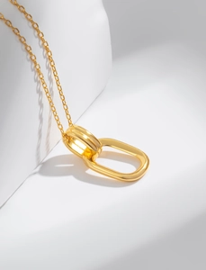 Macro shot of 925 sterling silver gold geometric interlocking rings necklace on white prop