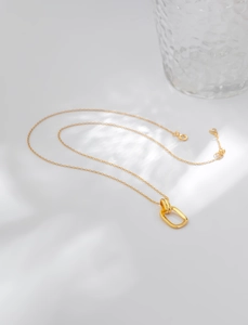 Macro view of interlocking gold geometric rings on a fine chain with water ripple light effect