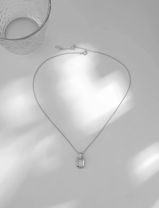 Macro view of S925 sterling silver geometric pendant with heart-shaped extender chain detail