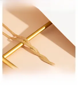 Detailed close-up of a long flat 18K gold-plated snake bone chain with fluid metal texture