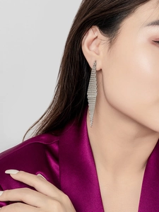 Macro view of long brass drop earrings with rhombus woven mesh and 18K gold plating