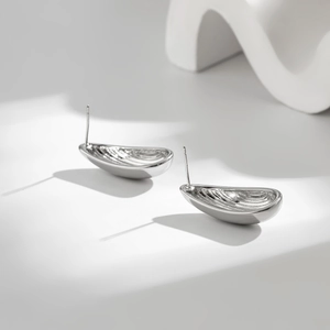 Detail view of 18K gold plated teardrop earrings showing textured inner surface and polish