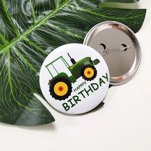 Cartoon tractor birthday pin-back buttons with green leaf decor on white background