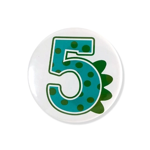 Detailed view of number 5 dinosaur cartoon badge with green scales for birthday party