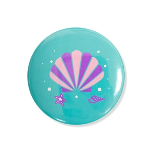 Detail of round mermaid badge with teal background, purple shells and starfish motif